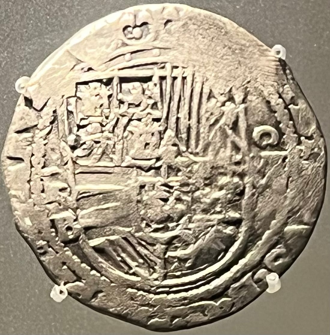 An 8 reales cob showing the crowned Habsburg shield with mint mark and assayer letters beside it